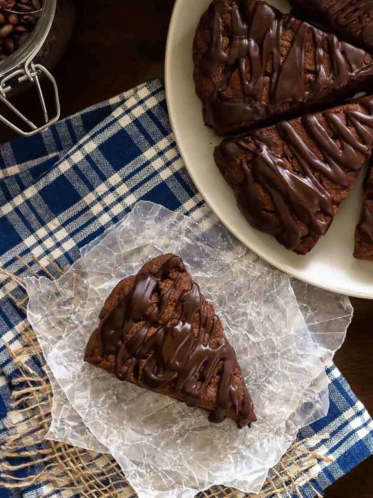 These double chocolate scones are easy to make and are decadent enough to be dessert, but since they're scones you can probably justify having them for breakfast! Buttery and flaky chocolate scones, filled with chocolate chips, and topped with a chocolate glaze - in short, they're amazing.