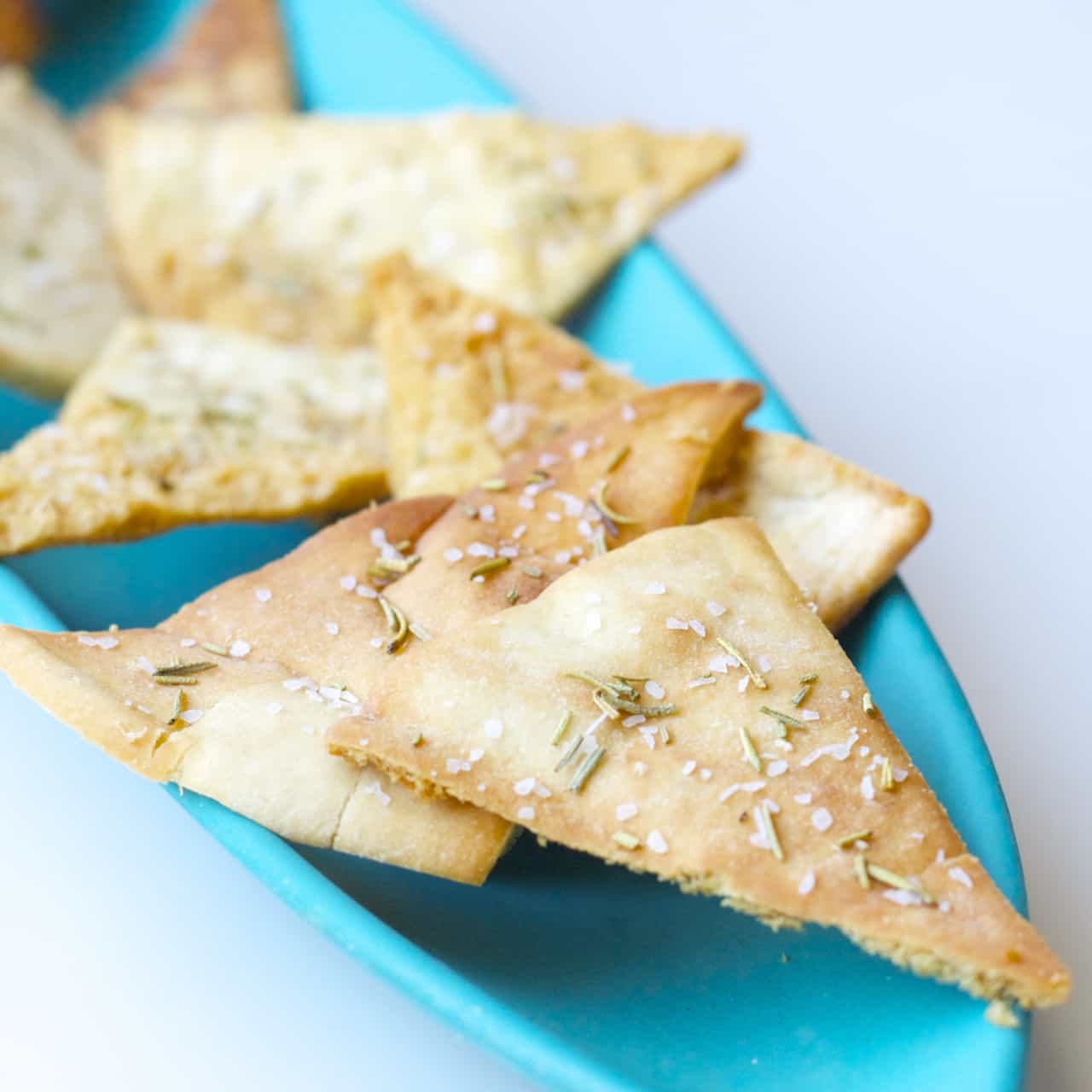 These homemade pita chips are seasoned with salt and rosemary and baked to crispy perfection. An easy snack to make at home!