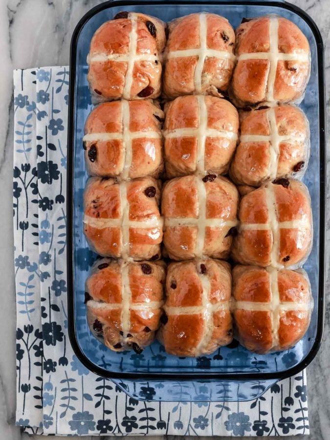 Soft and fluffy hot cross buns filled with raisins and topped with a honey lemon glaze - they make the perfect treat for the Easter season!