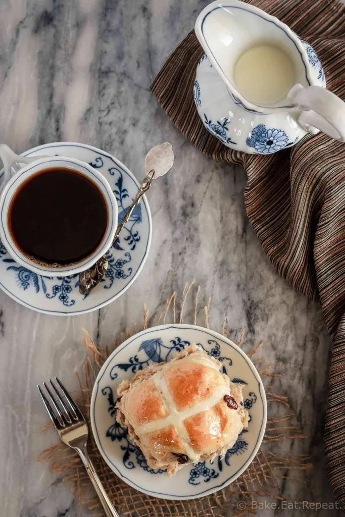 Soft and fluffy hot cross buns filled with raisins and topped with a honey lemon glaze - they make the perfect treat for the Easter season!