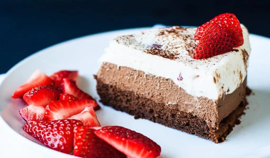 Chocolate Mousse Cake - A decadent triple chocolate strawberry mousse cake that is perfect for a special occasion. Flourless chocolate cake, dark chocolate mousse, and a white chocolate strawberry mousse - a chocolate lover's dream!