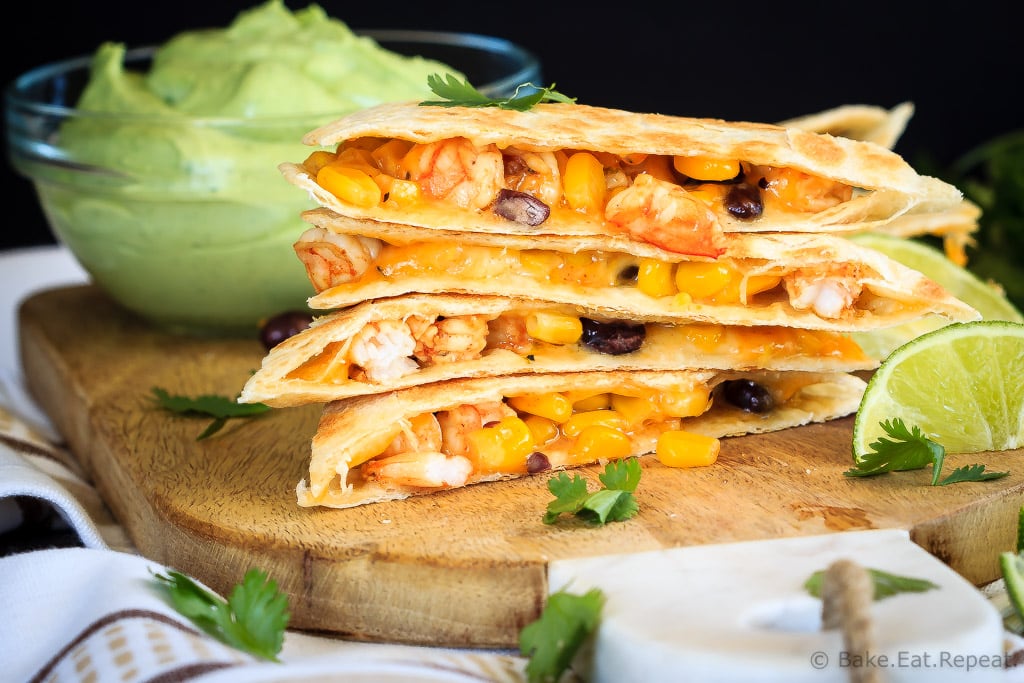 Shrimp quesadillas filled with corn, black beans and cheese, and an avocado cilantro lime cream dipping sauce. Quick and easy and everyone loves them!