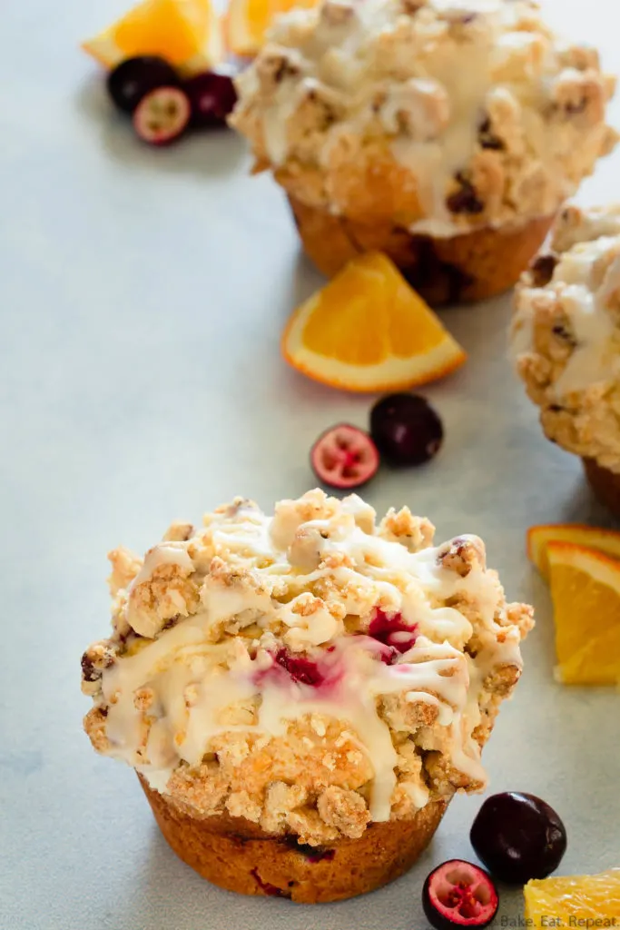 eggnog cranberry orange muffins with a crumb topping and an orange glaze