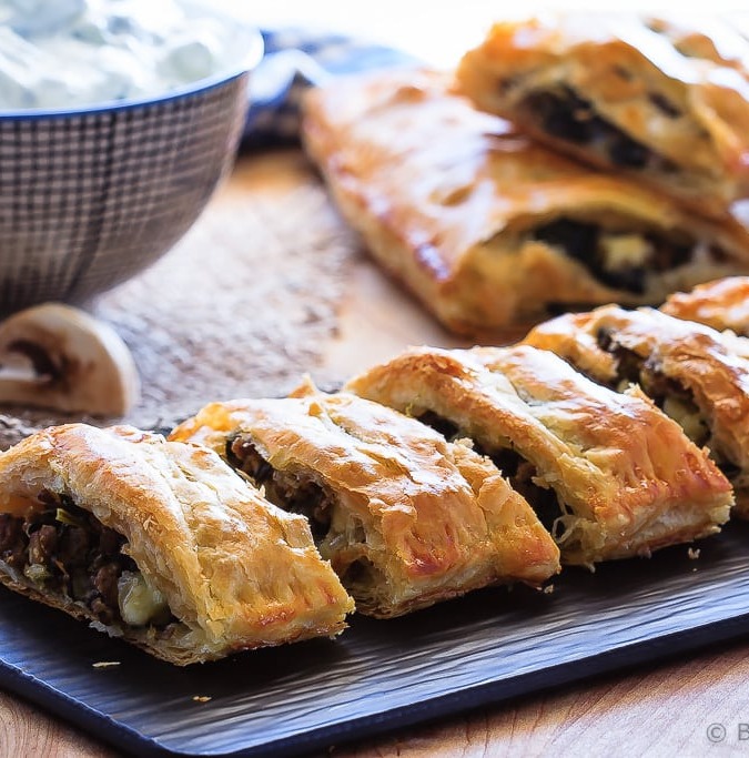 Beef Spinach and Mushroom Strudel - An easy appetizer made with puff pastry that everyone will love - this savoury strudel is filled with ground beef, mushrooms, spinach and feta cheese and served with tzatziki dip.