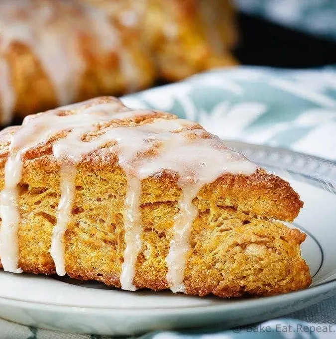 Pumpkin Scones - Light and fluffy pumpkin scones topped with a sweet maple glaze. These scones are the perfect breakfast treat to enjoy with your morning coffee!