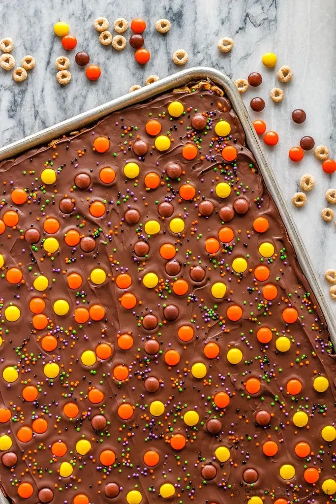 These crunchy chocolate peanut butter granola bars use cereal and oats for an easy, no bake treat - with yellow and orange candy for a fun Halloween snack!