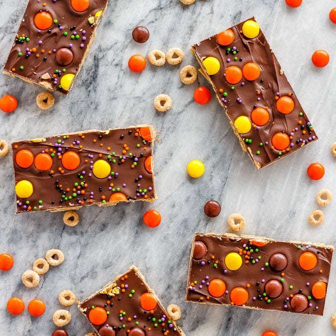 These crunchy chocolate peanut butter granola bars use cereal and oats for an easy, no bake treat - with yellow and orange candy for a fun Halloween snack!