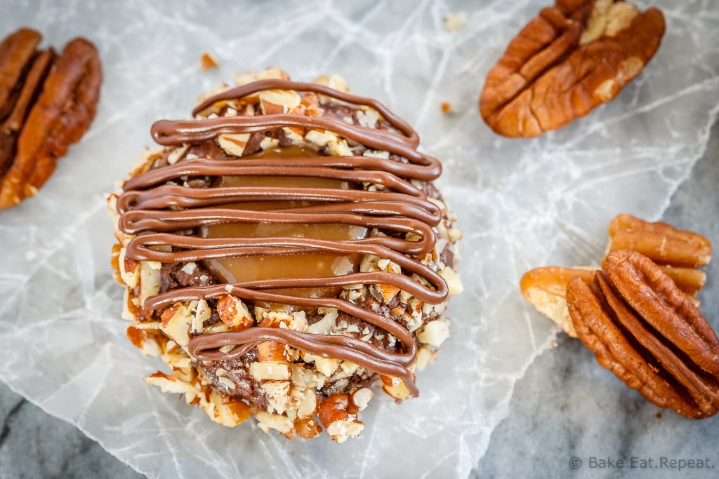 These turtle thumbprint cookies are amazing! Rich chocolate cookies rolled in chopped pecans, topped with salted caramel sauce and drizzled in chocolate!