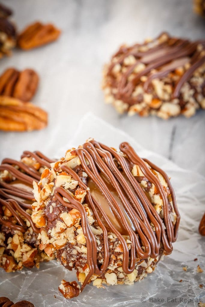 These turtle thumbprint cookies are amazing! Rich chocolate cookies rolled in chopped pecans, topped with salted caramel sauce and drizzled in chocolate!