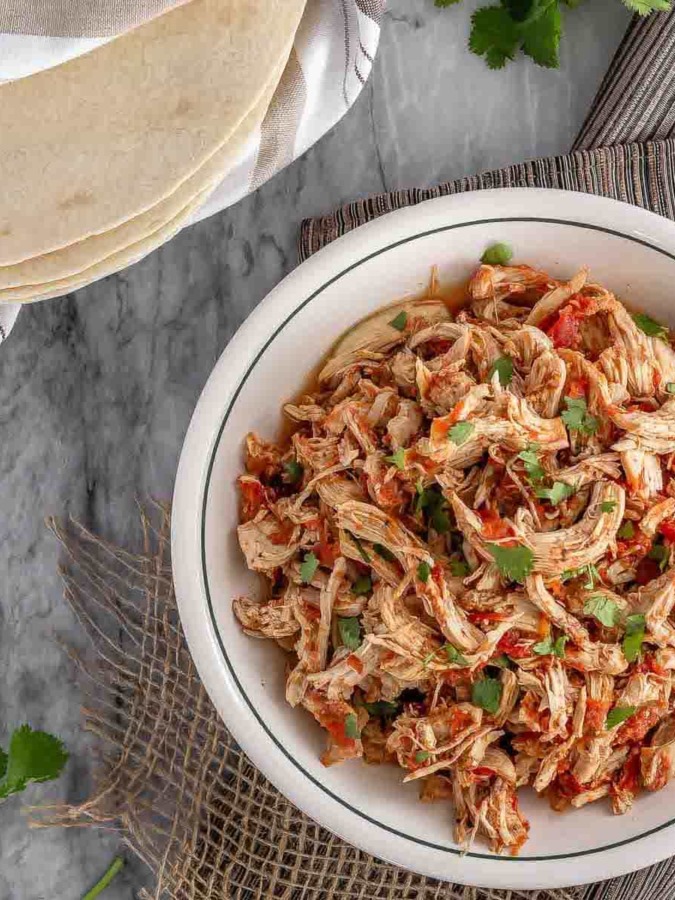 These 3 ingredient chicken tacos are so easy to make and so tasty - the perfect meal for those busy weeknights. A 30 minute meal in your Instant Pot (from fresh or frozen) or let it cook all afternoon in your slow cooker for amazing chicken tacos! This chicken taco meat is amazing in soft or hard tacos, or on nachos!