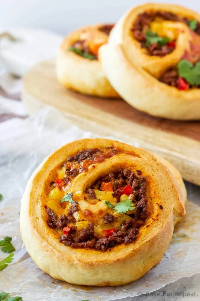 These taco pizza rolls are easy to make and taste amazing! Homemade pizza dough wrapped around taco meat, cheese and veggies - perfect for lunch or dinner!