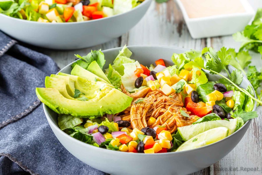 BBQ Chicken, corn, red peppers, black beans, and avocado in a romaine salad with creamy cilantro lime dressing