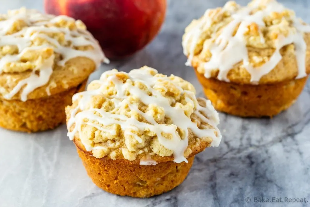 Fresh peach muffins with a crumb topping and a vanilla glaze