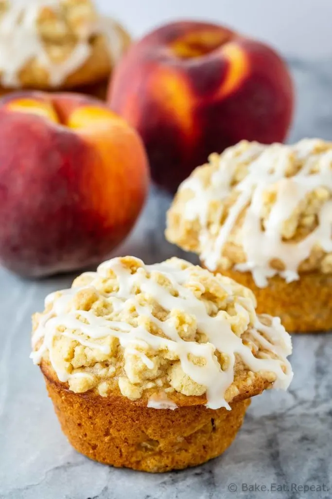 Peach muffins with a crumb topping and a vanilla glaze