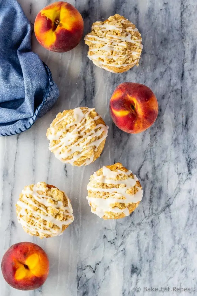 Peach muffins with a crumb topping and a vanilla glaze