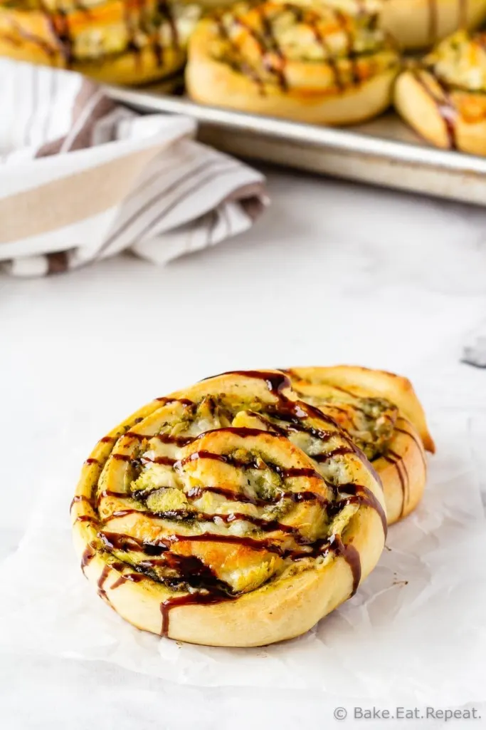 Easy homemade pizza rolls with pesto, chicken, mozzarella cheese, and balsamic glaze.