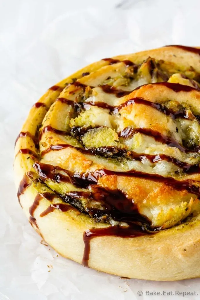 Easy to make pesto chicken pizza rolls drizzled with balsamic glaze.