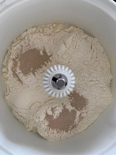 Milk, water, sugar, salt, flour and yeast in mixer for making bread.