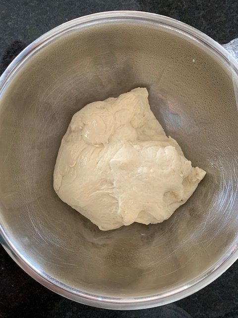 Bread dough in an oiled bowl, set to rise.