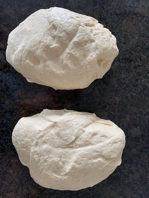 Two piece of bread dough ready to shape into loaves.