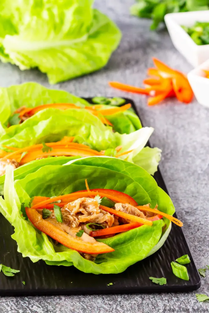 Easy to make slow cooker hoisin chicken lettuce wraps with toppings.