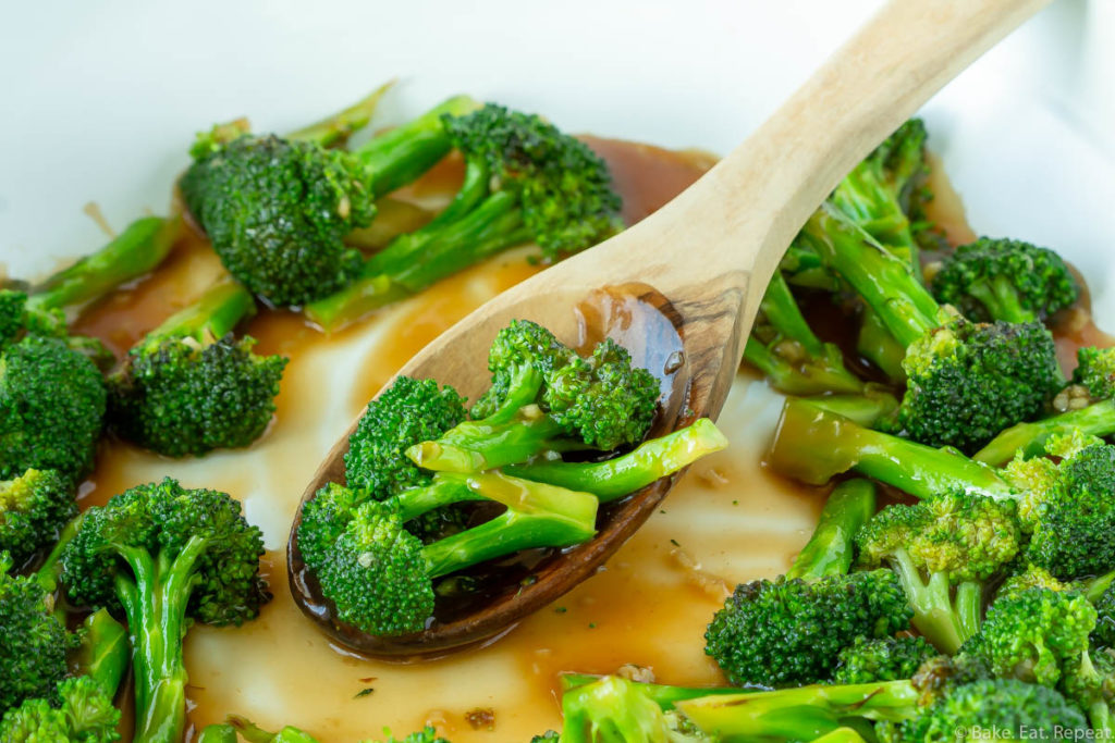 Asian broccoli stir fry in a skillet with a spoon.