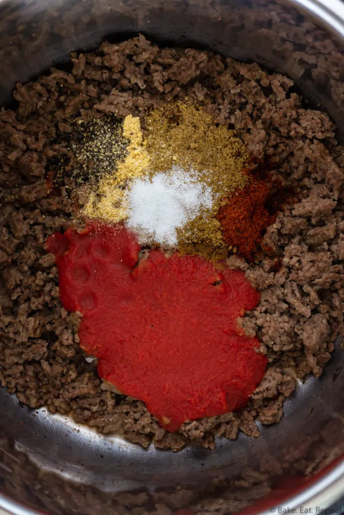 The ingredients for taco meat in the Instant Pot - ground beef, tomato sauce, and seasoning.